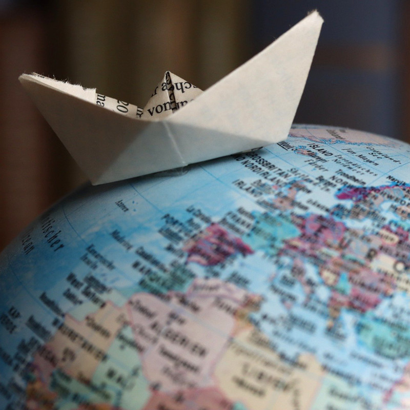 Barquito de papel sobre un globo terráqueo, foto por Joachim Schnürle (Pixabay)